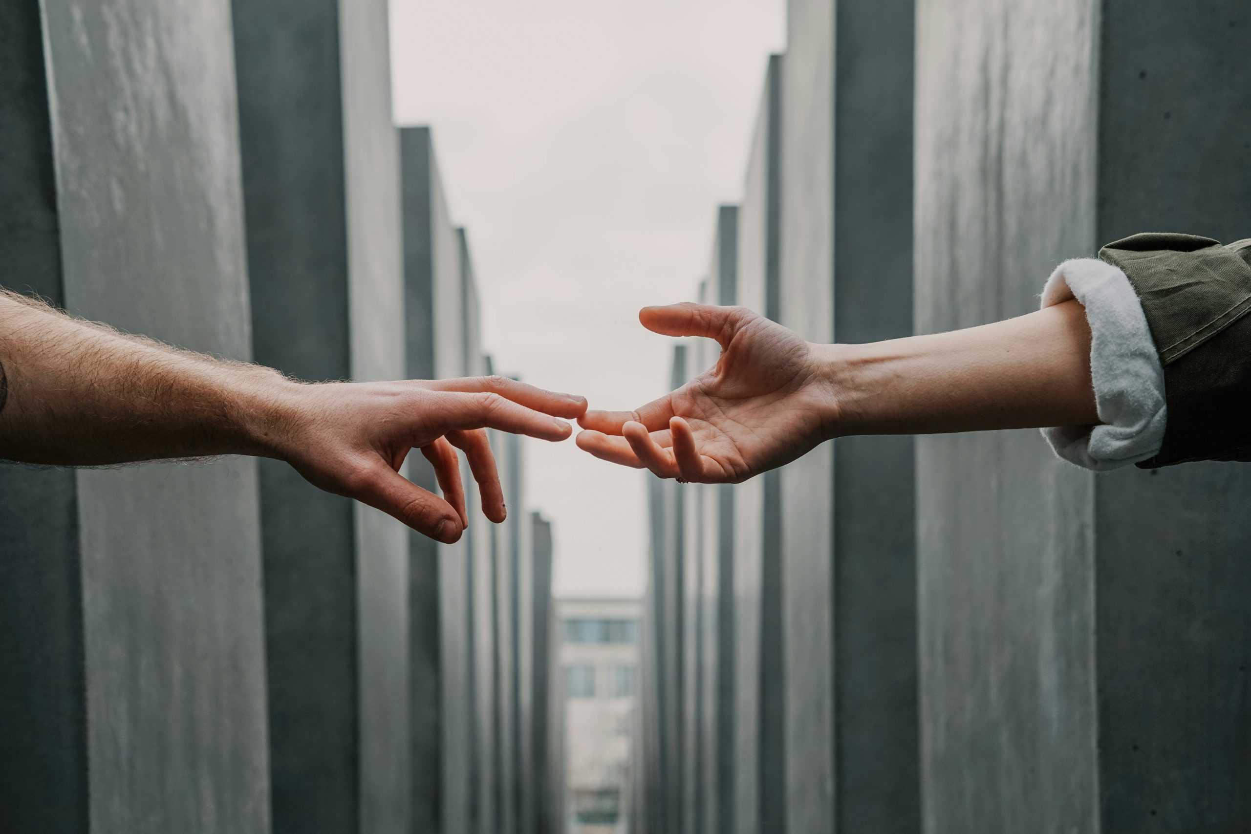 Fotografia concettuale, con due mani che cercano una connessione sociale.